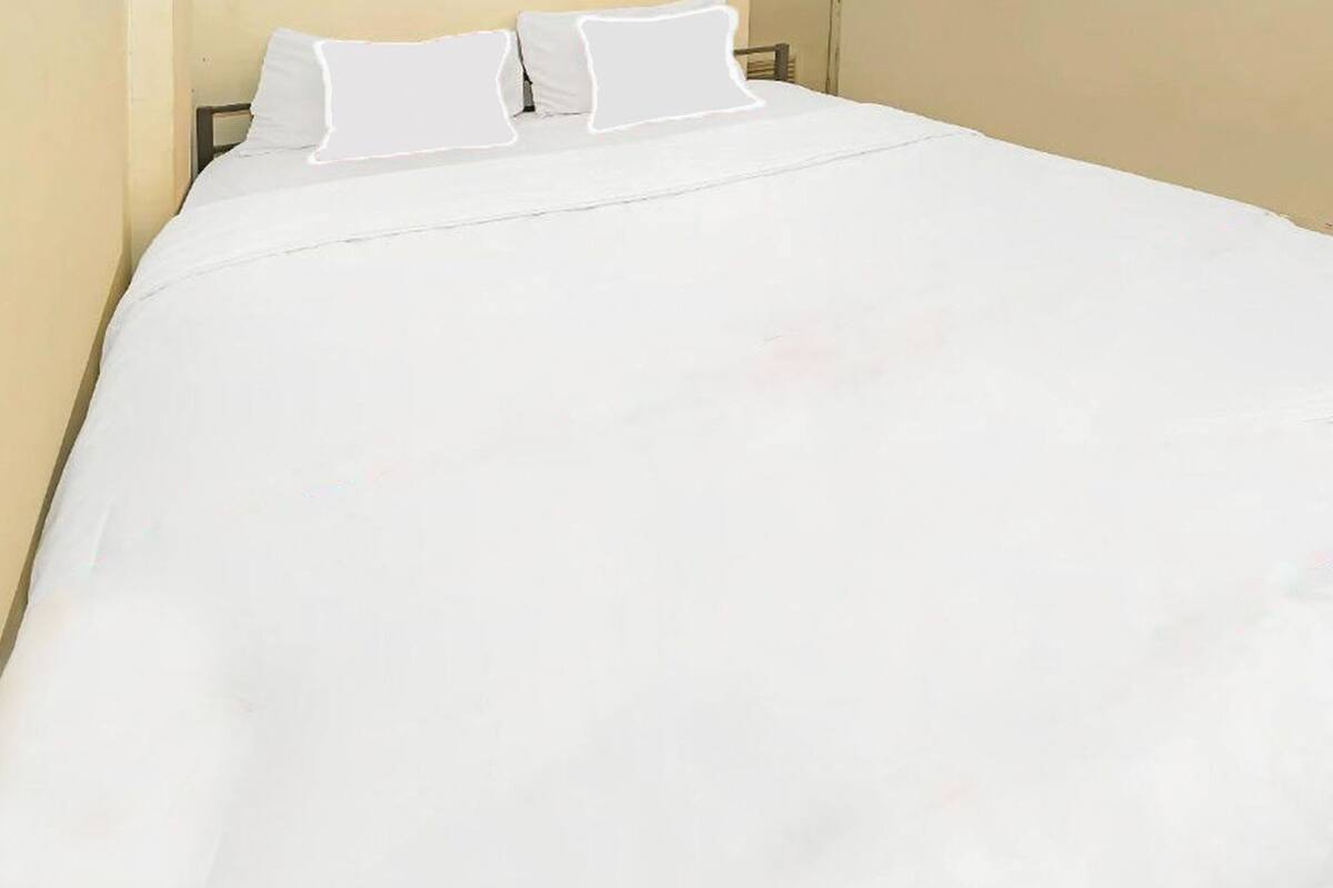 A bed with white bedding and two pillows.