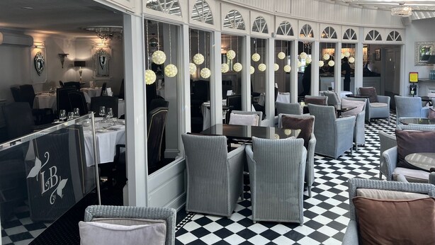 Un restaurant avec un sol à carreaux, des murs blancs et des lustres.