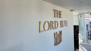 Un mur sur lequel est inscrit le texte « THE LORD BUTTE » et sur lequel est fixée une pièce décorative en métal qui ressemble à un château.