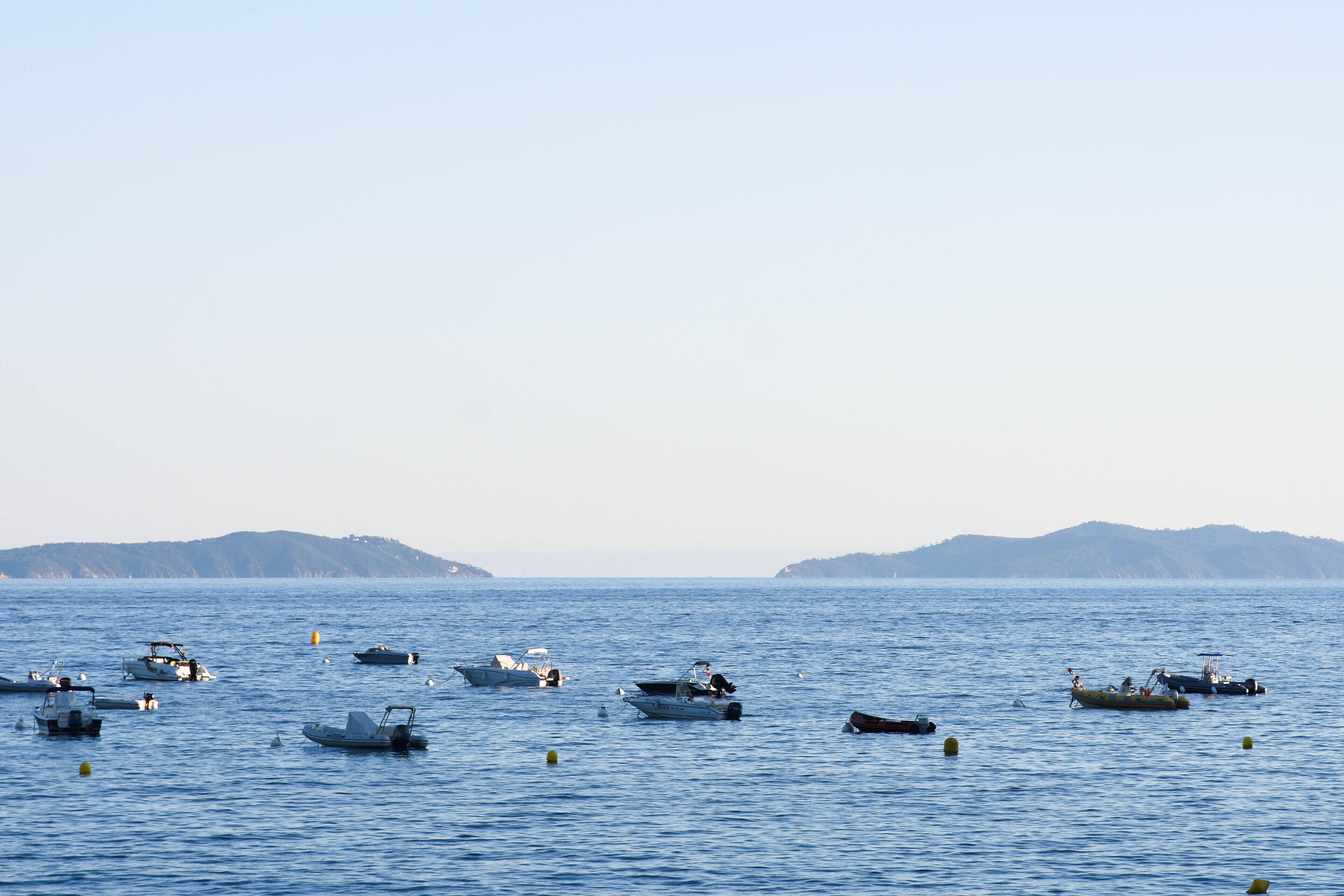 A calm sea with several boats scattered across the water.
