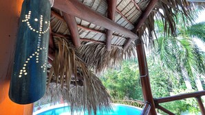 Una estructura de techo de paja con vigas de madera y una decoración colgante.