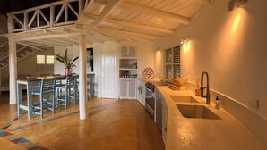 Una cocina amplia con una isla grande, armarios blancos y un grifo moderno.