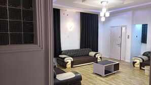 Uma sala de estar moderna com um sofá, uma mesa de centro e uma porta.