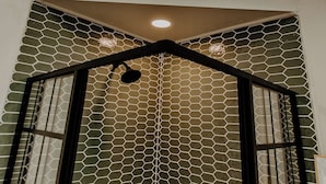 Ein Zimmer mit einem geometrischen Deckendesign, einer sechseckig gemusterten Wand und einem Oberlicht.