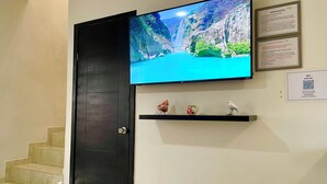 A hotel lobby with a large TV on the wall displaying a scenic waterfall, a reception desk, and a QR code for WiFi access. - OFFER Excellent Private House, Garden, BBQ, Garage.  (Ciudad Valles)