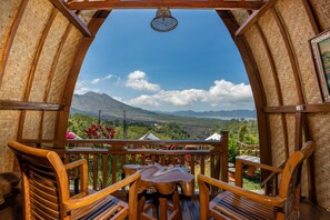 A wooden deck with a view of mountains and greenery. - Tiing Bali Guest House (Kintamani)