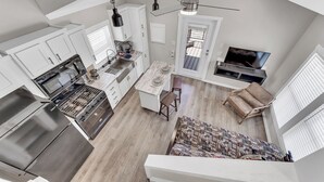 A modern kitchen with a built-in oven, a dining area with a marble table, and a TV mounted on a wall. - Indian Point Cabin 4 near Silver Dollar City, Table Rock Lake & Branson (Branson)