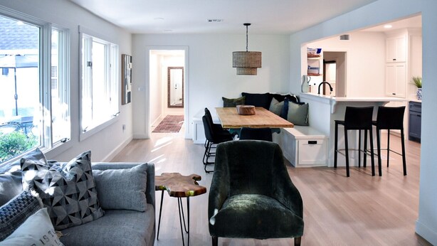 A modern interior with a dining area, kitchen, and seating space. - Renovated Historic 5 Bedroom Home Close to OU Campus! (Norman)