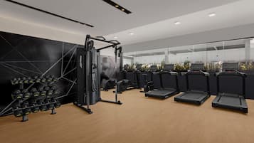 A modern gym with weight machines, treadmills, and dumbbells.
