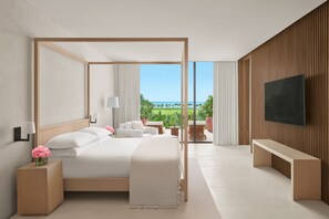 A modern hotel room with a large bed, a TV, a balcony with a view of the ocean, and a wooden wall. - The Riviera Maya EDITION At Kanai (Playa del Carmen)