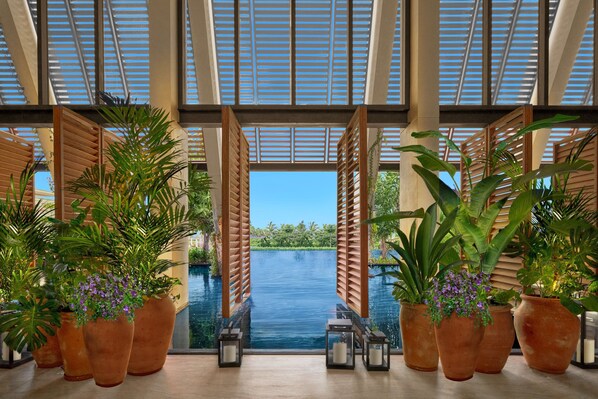 A pool area with large potted plants and wooden shutters. - The Riviera Maya EDITION At Kanai (Playa del Carmen)