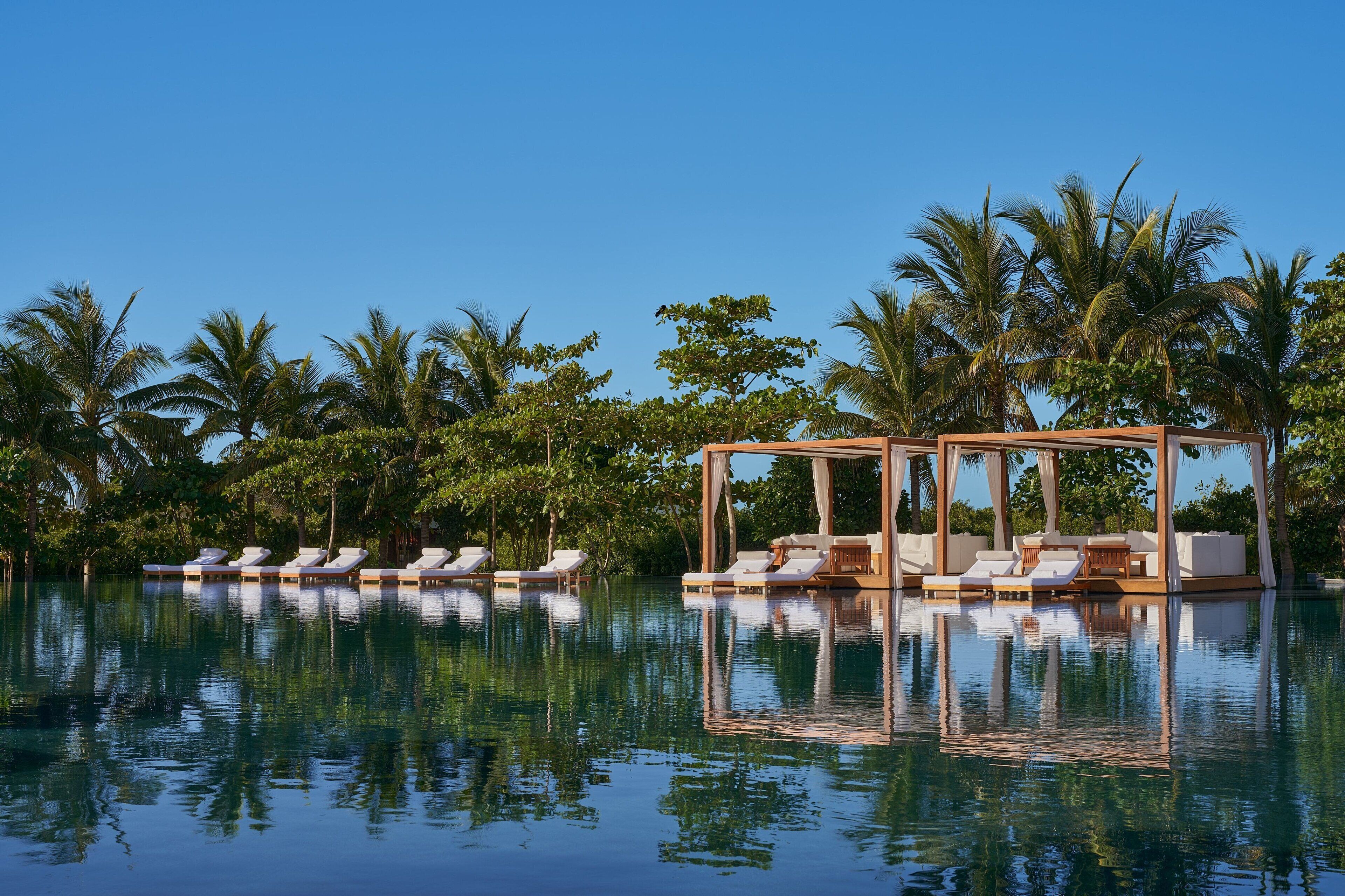 A poolside area with lounge chairs and a wooden gazebo.