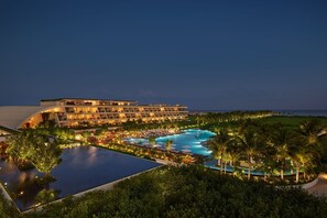 A resort with a large pool, multiple swimming areas, and a building with balconies overlooking the pool. - The Riviera Maya EDITION At Kanai (Playa del Carmen)