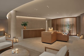A modern lobby with a reception desk, seating area, and ambient lighting.