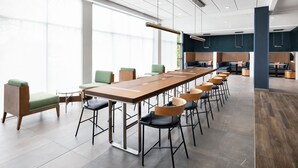 A modern conference room with a long table, chairs, and a high ceiling with recessed lighting. - Courtyard By Marriott New Castle (New Castle)