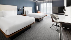 A hotel room with two beds, a desk, a chair, a TV, and a large window with curtains. - Courtyard By Marriott New Castle (New Castle)