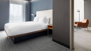 Quarto de hotel moderno com uma cama grande, uma mesa e uma cadeira.