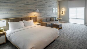 A modern hotel room with a large bed, a sofa, a small table, and a nightstand. - Towneplace Suites By Marriott Canfield (Canfield)