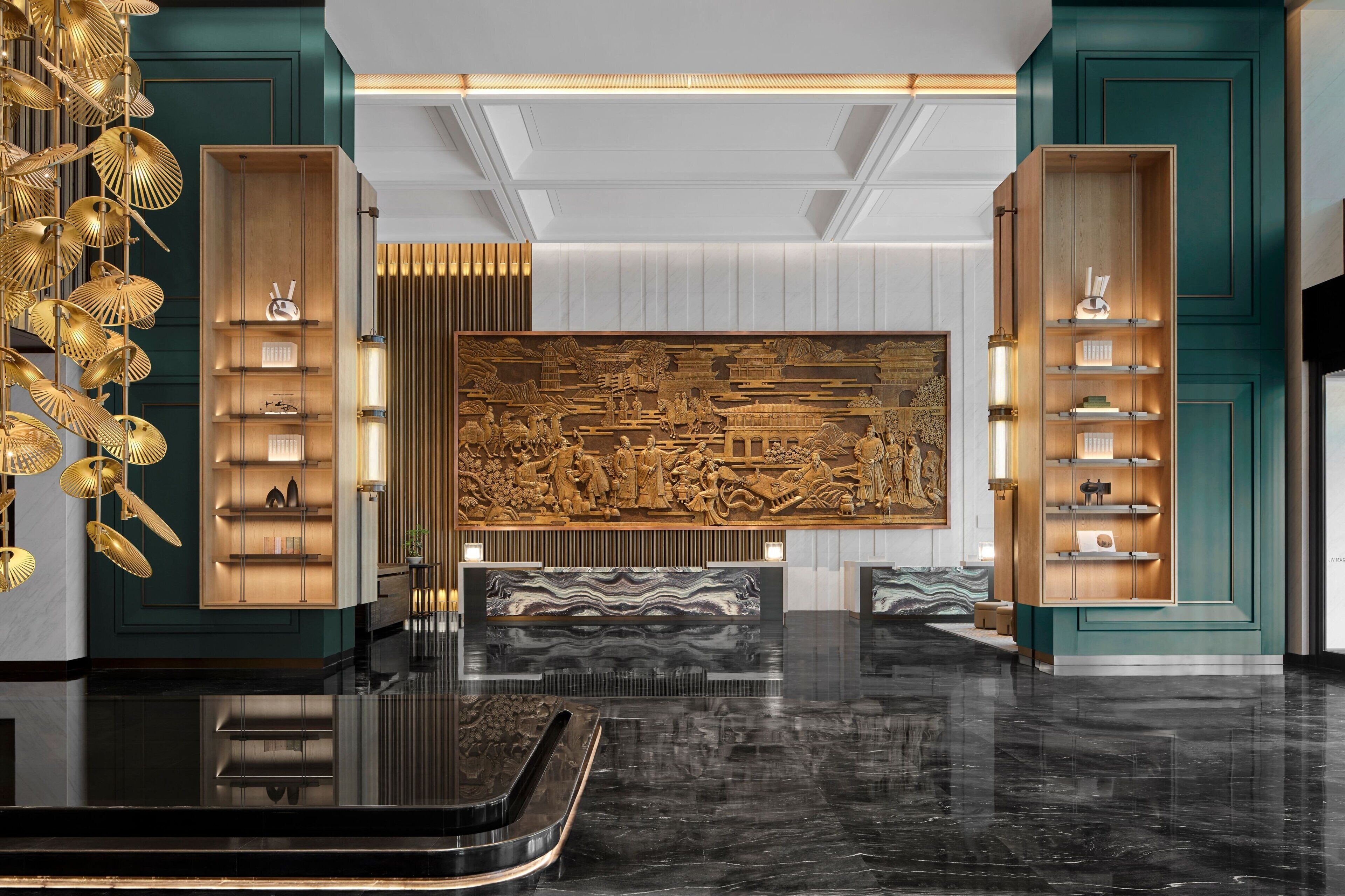 A modern lobby with a central sculpture, wooden shelving units, and a reflective black floor.