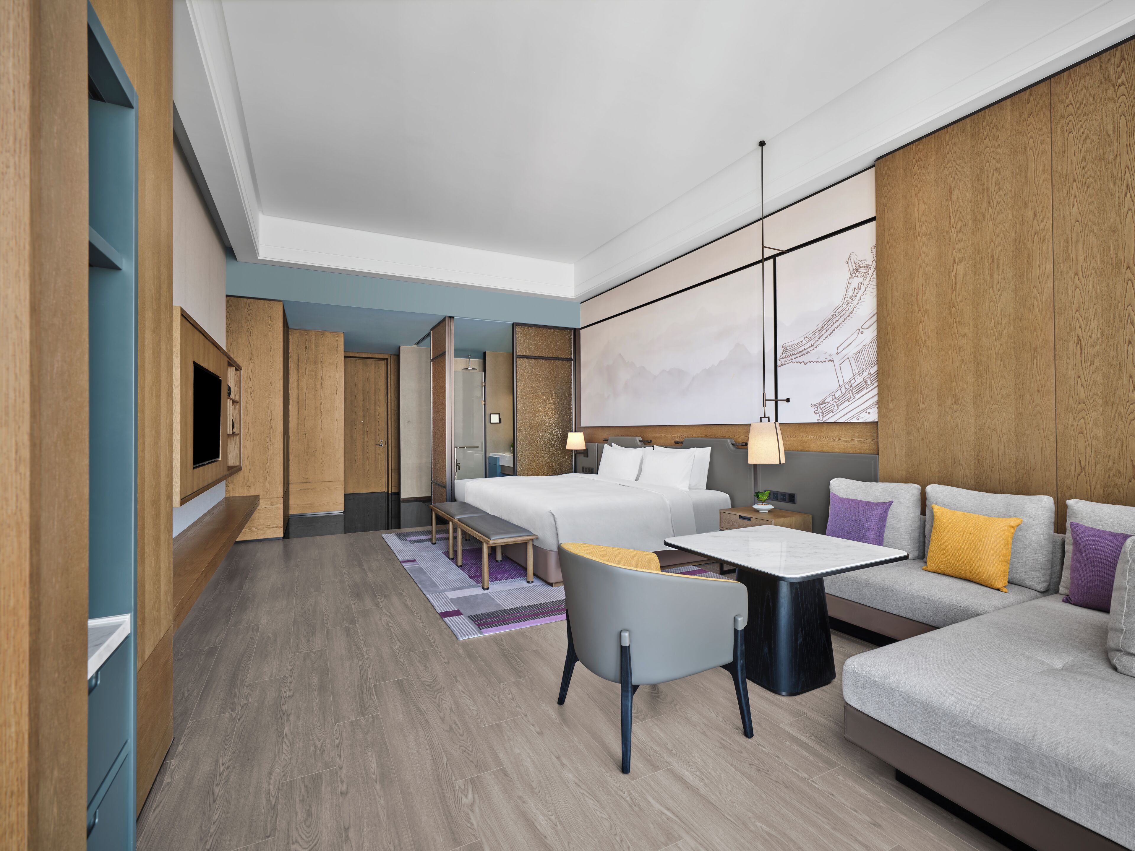 Una habitación de hotel moderna con cama, sofá, escritorio y televisor.