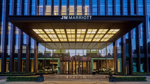 Der Eingang eines JW Marriott Hotels mit modernem Design, inklusive überdachter Eingangsbereich und Glasfassade.