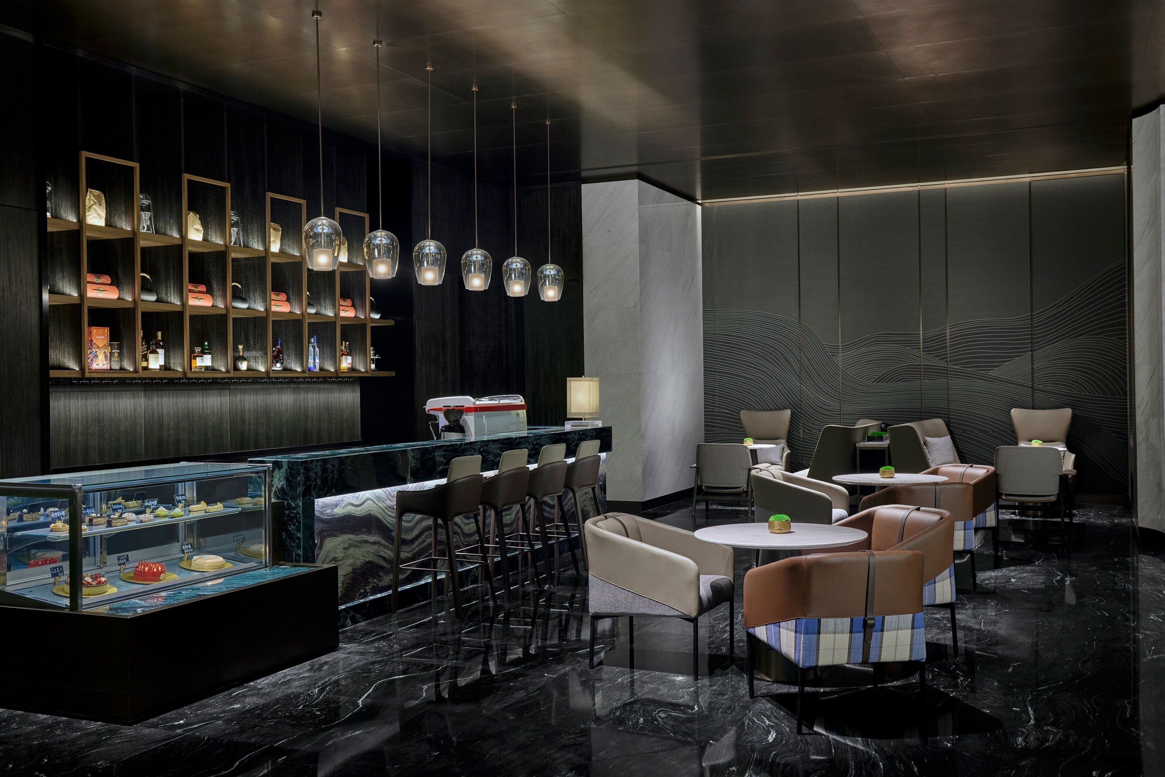 A modern bar area with a marble countertop, multiple seating options, and a display case with various items.