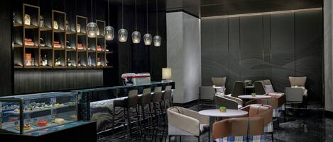 A modern bar area with a marble countertop, multiple seating options, and a display case with various items.