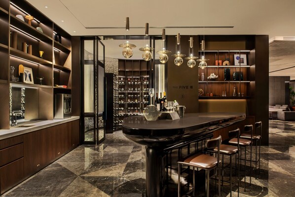 A modern bar area with a marble floor, bar stools, and a wine rack with bottles. - Sheraton Xuzhou (Xuzhou)