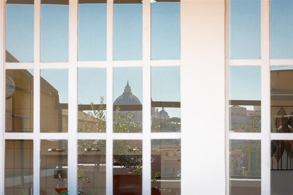 A room with a large window reflecting a building with a dome.