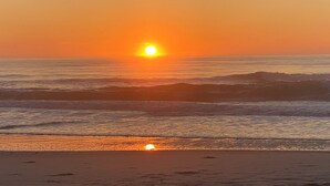 A sunset over the ocean with waves approaching the shore. - EXCEPTIONAL LOCATION - LUXURY VILLA STEPS AWAY FROM THE BEACH AND POOL (Corolla)