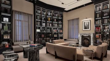 A library with bookshelves, a fireplace, and seating areas.