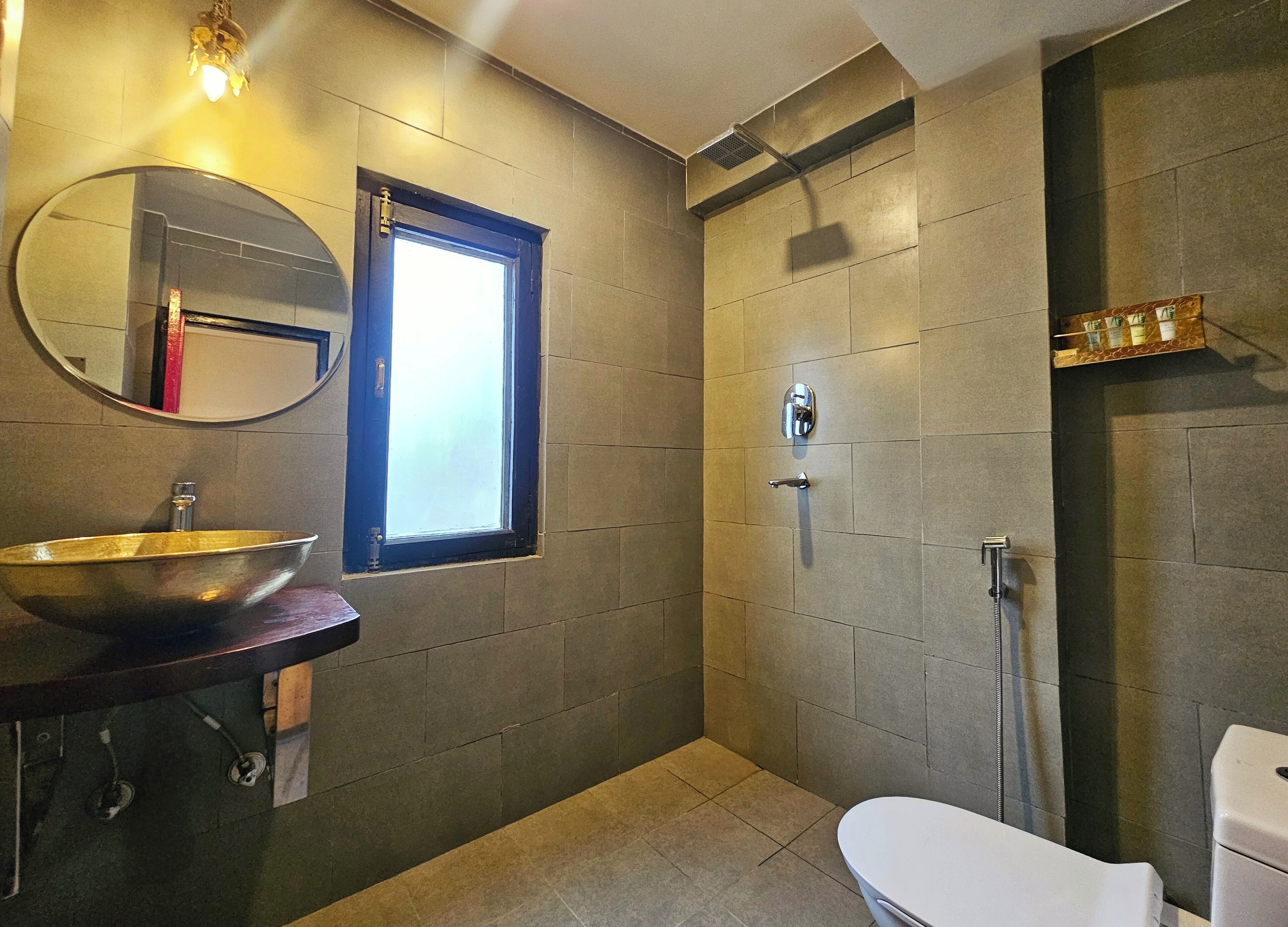 A modern bathroom with a large mirror, a vessel sink, a toilet, and a shower.