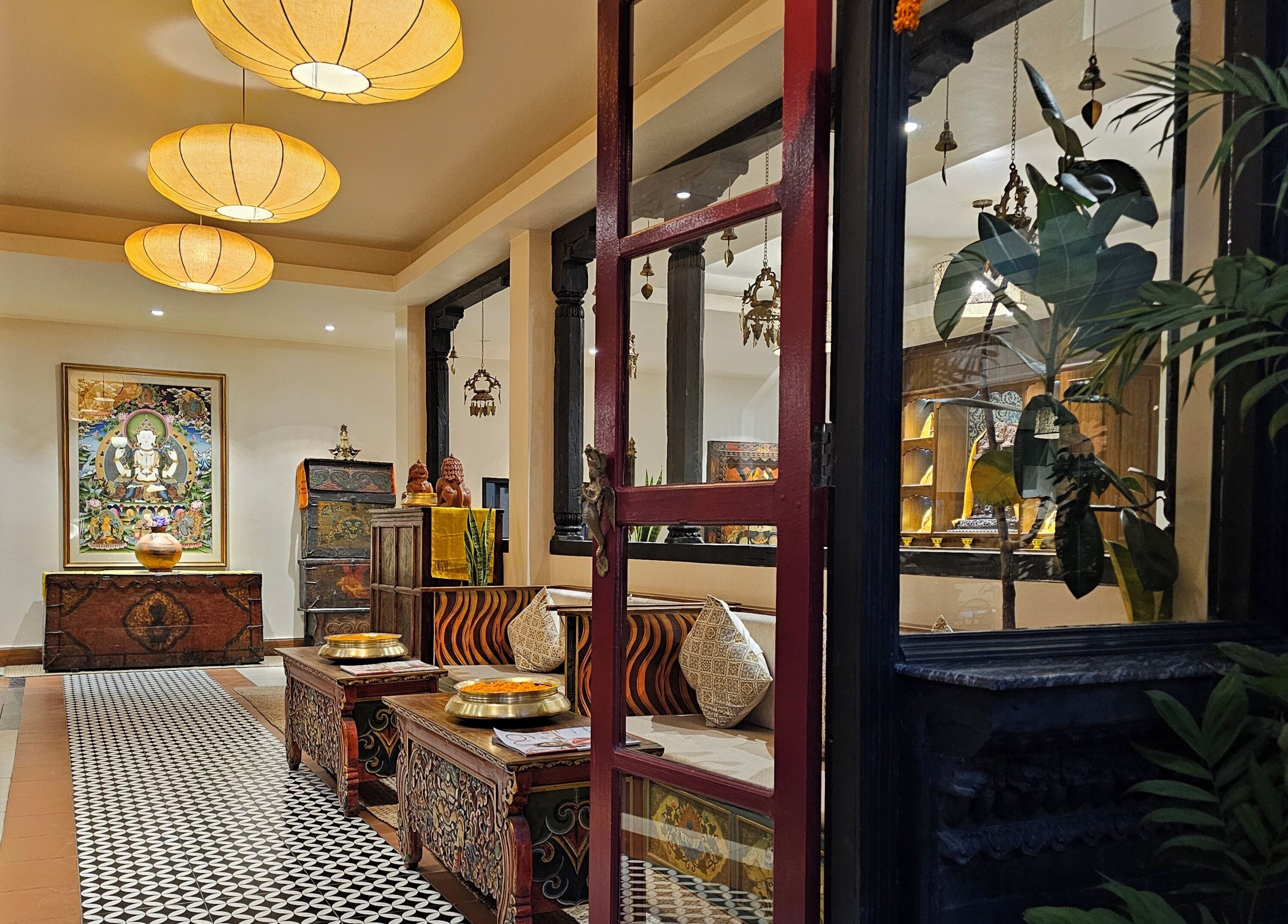 Un intérieur traditionnel avec un sol à motifs, des meubles richement décorés et des éléments décoratifs suspendus.