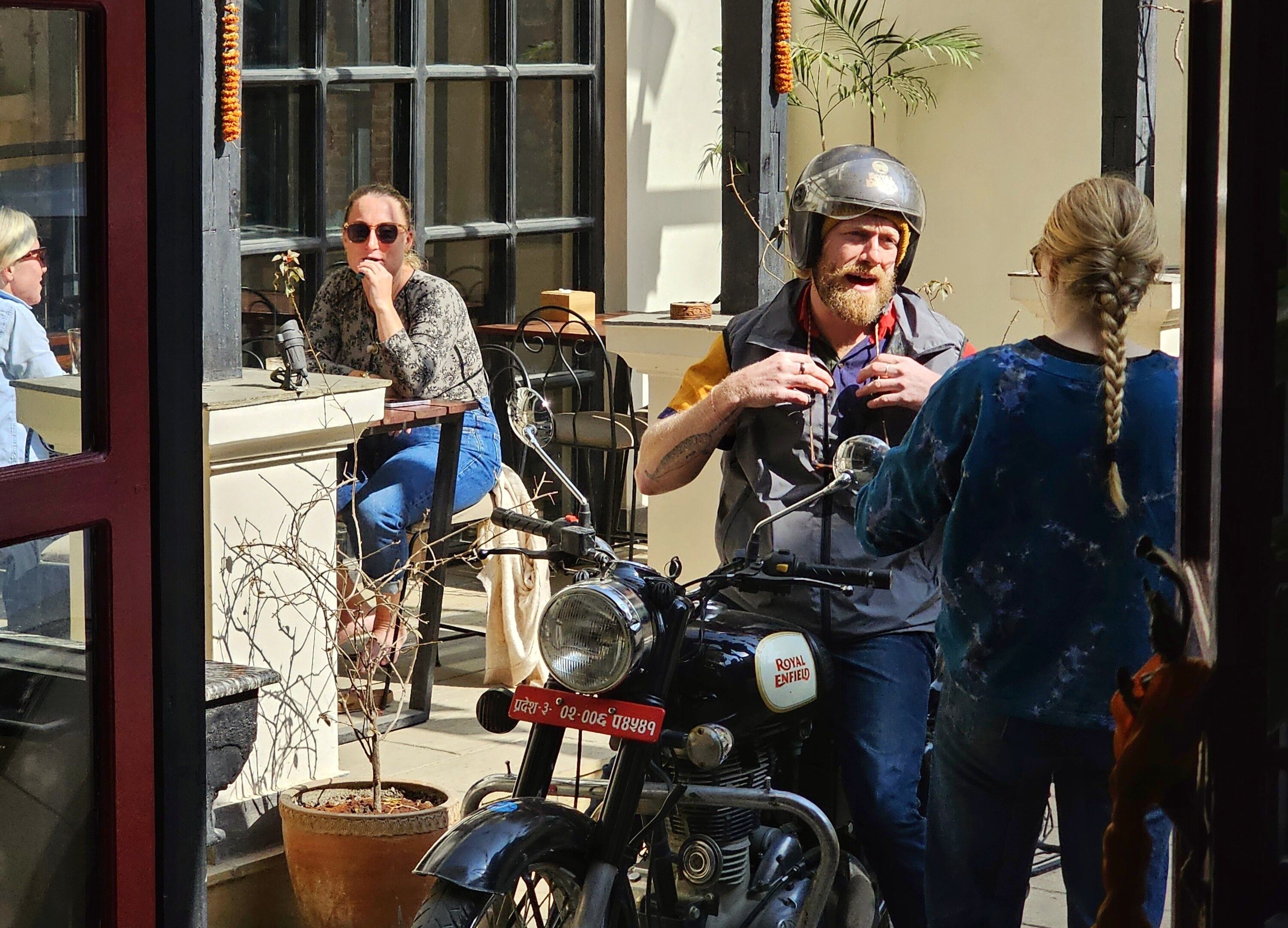 A motorcycle with a visible license plate and a person standing beside it.