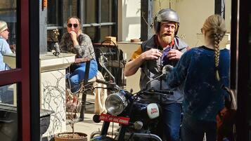 A motorcycle with a visible license plate and a person standing beside it.