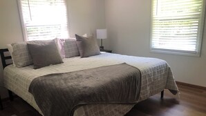 A bedroom with a bed, pillows, a lamp, and a window with blinds. - Raystown Lake getaway <br>3 bedroom 2 bath<br> (Huntingdon)