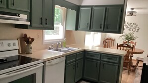 A kitchen with green cabinets, a white stove, and a sink. - Raystown Lake getaway <br>3 bedroom 2 bath<br> (Huntingdon)