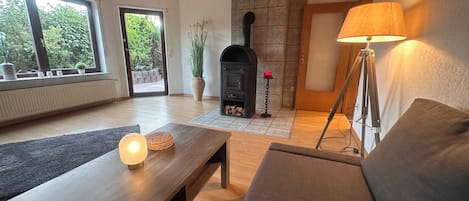 A modern living room with a fireplace, a sofa, a coffee table, and a lamp.
