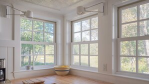 Una cocina con ventanas amplias, encimera de madera y un bol con limones.