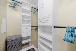 A walk-in closet with open shelves, a hanging rod, and a laundry basket. - Centrally Located Beach Bungalow (Myrtle Beach)