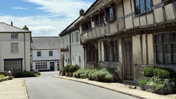 Una calle estrecha flanqueada por casas tradicionales con entramado de madera.