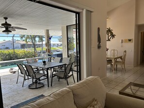 A spacious patio with a dining table and chairs, a pool, and a ceiling fan. - RUM CAY GETAWAY: South facing waterfront home, private pool/spa, bar, and dock. (Punta Gorda)