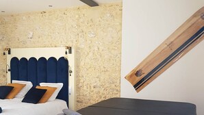 A bedroom with a bed, a massage table, and a wall-mounted board.