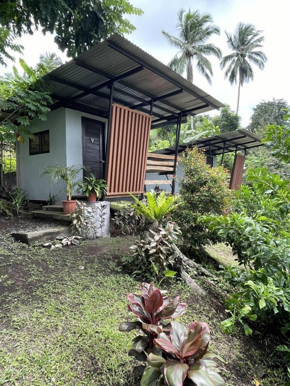A small, single-story building with a corrugated metal roof and a wooden door.