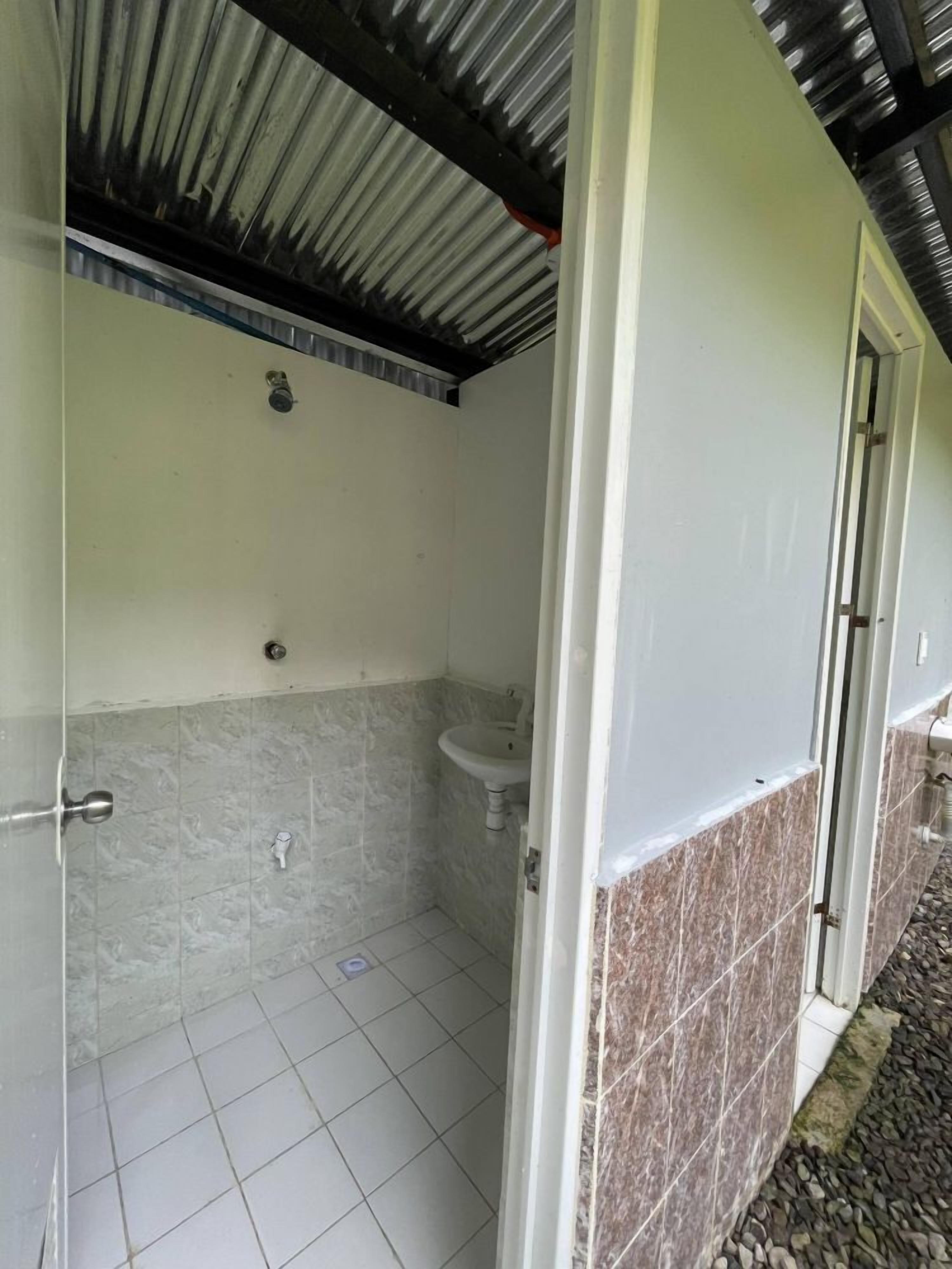 Une salle de bain avec une douche, un lavabo et un sol carrelé.