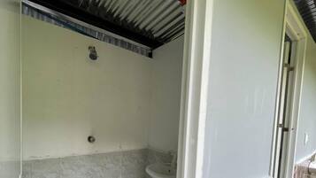 Une salle de bain avec une douche, un lavabo et un sol carrelé.