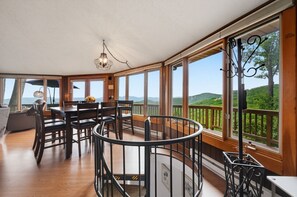 A spacious room with a dining area, large windows, and a view of the outdoors. - Spectacular Views - 4 bedrooms, Sleeps 9 (Beech Mountain)