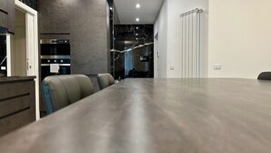 Een vergaderruimte met een lange tafel, lederen stoelen, een ingebouwde oven en een marmeren achterwand.