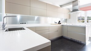 A modern kitchen with a built-in sink, stainless steel appliances, and a window overlooking the city.