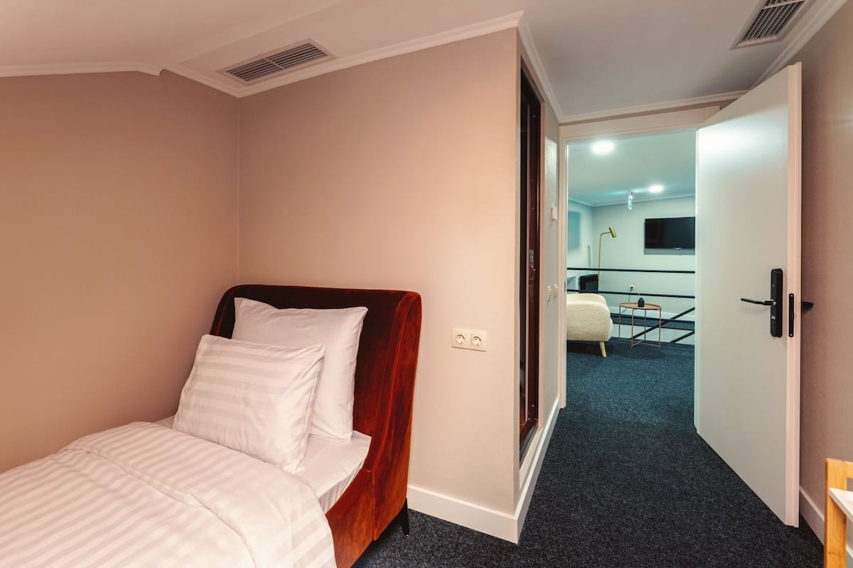 A hotel room with a bed, a desk, and a chair.